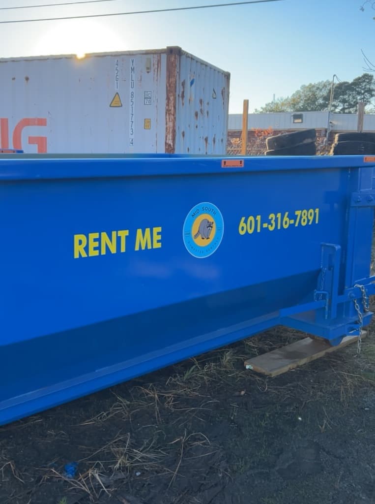 Dumpster in a Central Mississippi backyard next to a deck demolition project