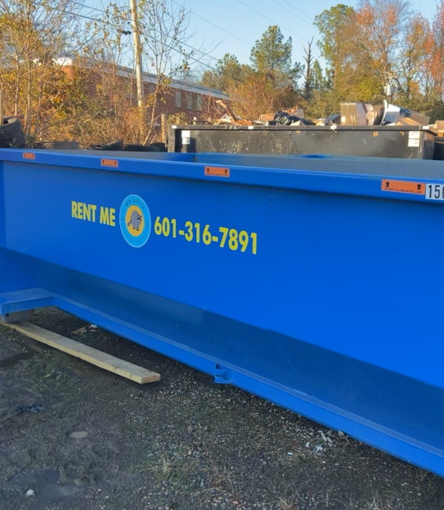 Roll-off dumpster placed safely on a driveway using protective wooden boards